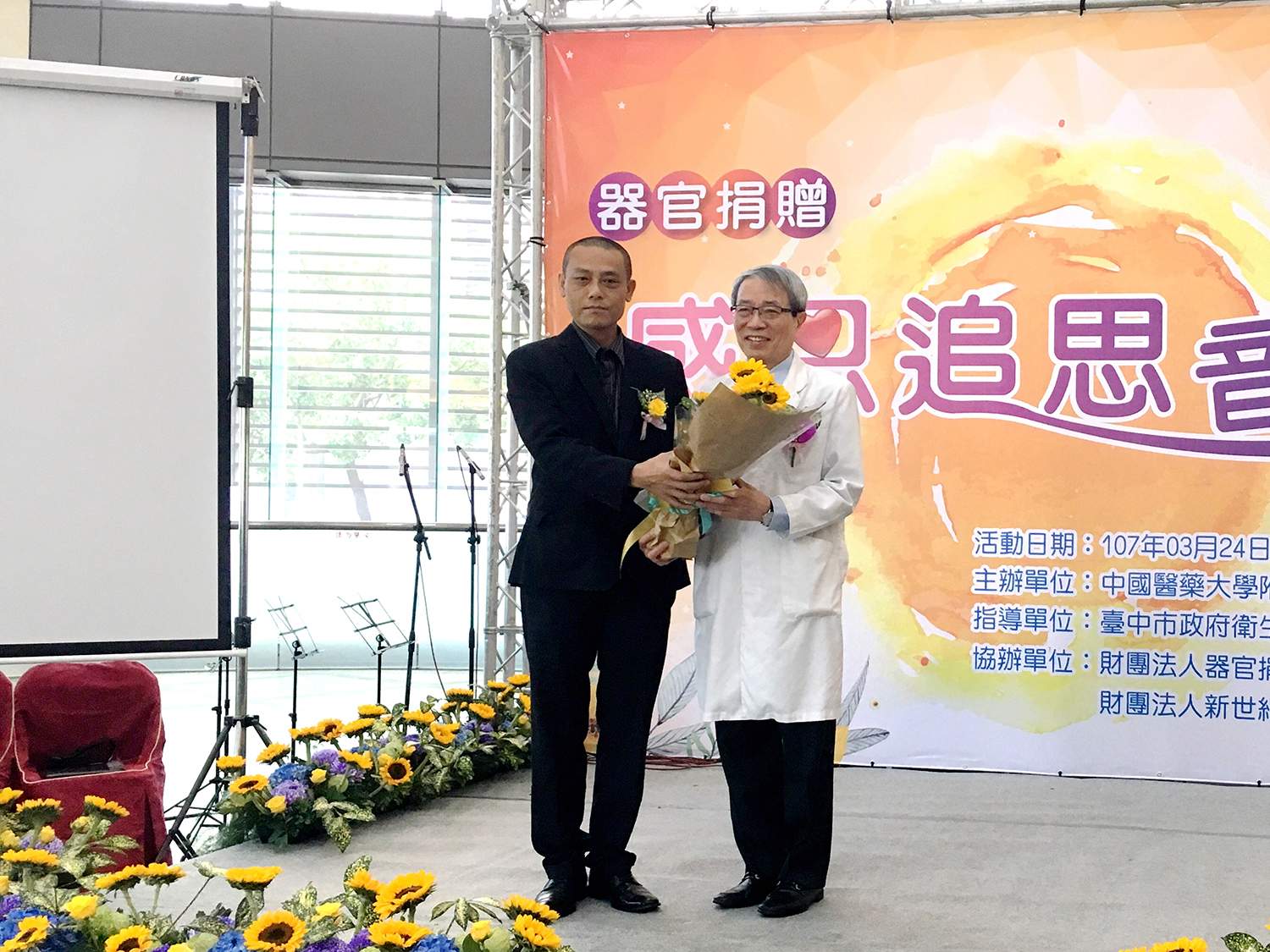 換肝者黃先生獻花給中國附醫器官移植中心院長鄭隆賓。
